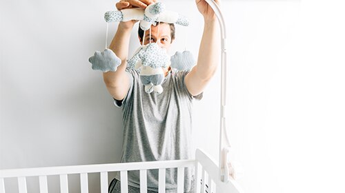 Papá arreglando la cuna del bebé
