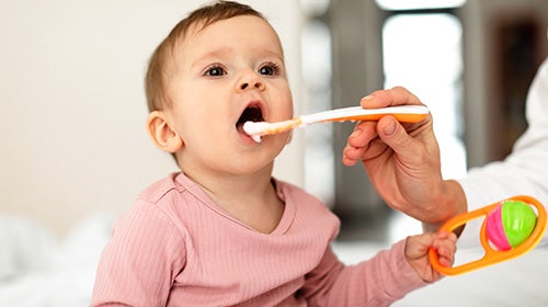 Bebé con la boca abierta recibiendo comida